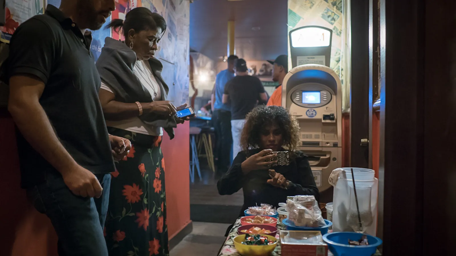 Filmmaker takes a photo with her cell phone in front of a dimly lit bathrooom.